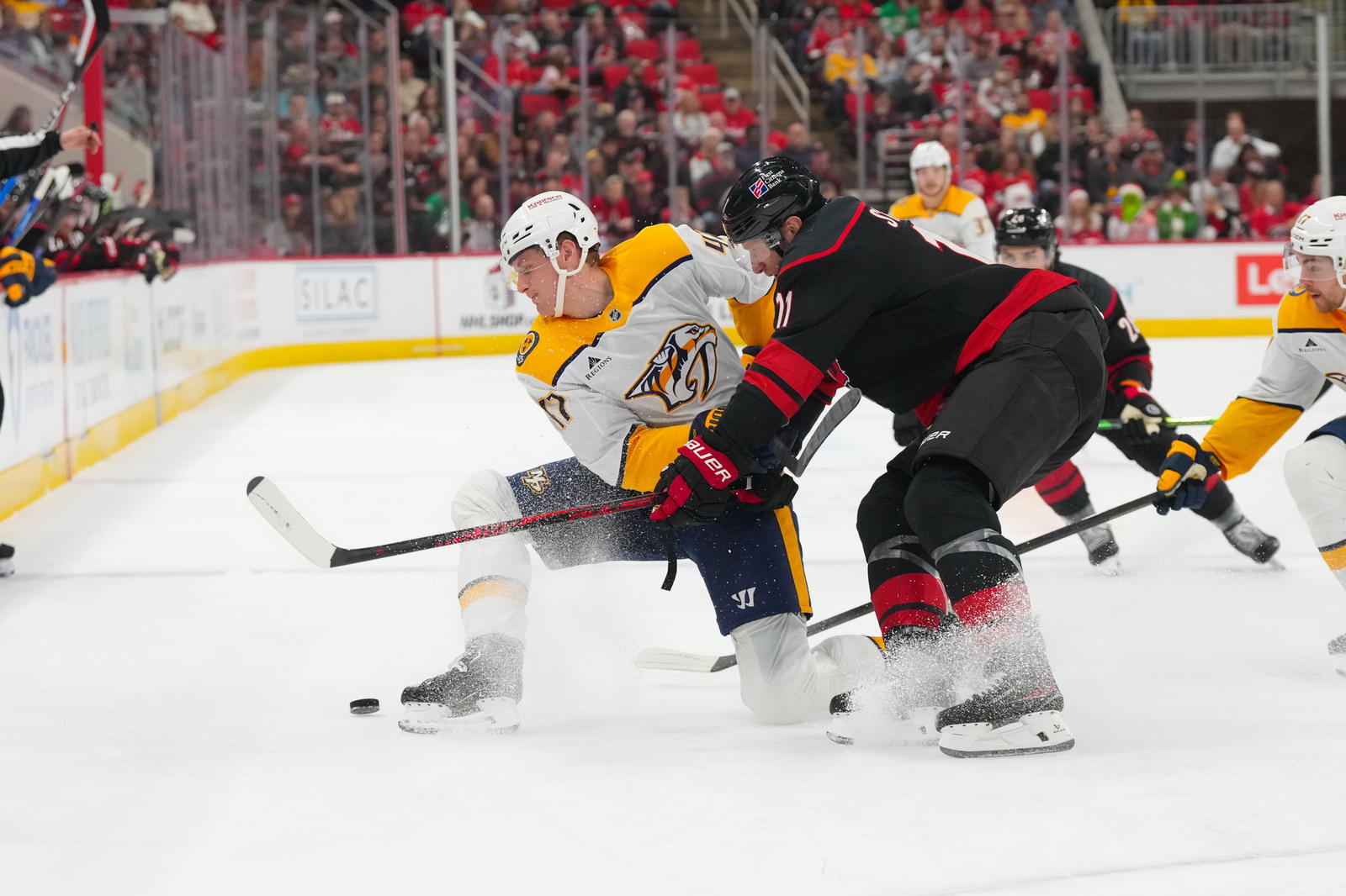 Dec 6, 2025; Raleigh, North Carolina, USA; Nashville Predators right wing Michael McCarron (47) is checked by Carolina Hurricanes center Jordan Staal (11) during the second period at Lenovo Center. Mandatory Credit: James Guillory-Imagn Images