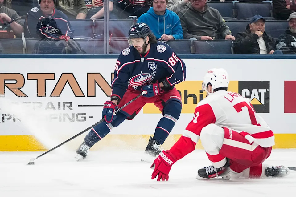 Blue Jackets right wing Kirill Marchenko skates around Red Wings center Dylan Larkin on Dec. 4.
