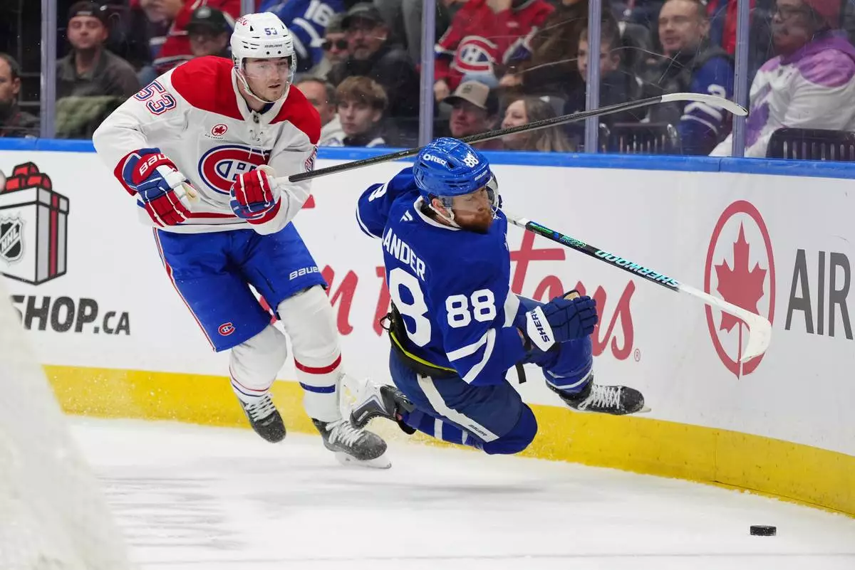 Montréal Canadiens defenceman Noah Dobson (53) picks up a penalty for tripping Toronto Maple Leafs right wing William Nylander (88) during second period NHL hockey action in Toronto on Saturday, Dec. 6, 2025. (Frank Gunn/The Canadian Press via AP)
