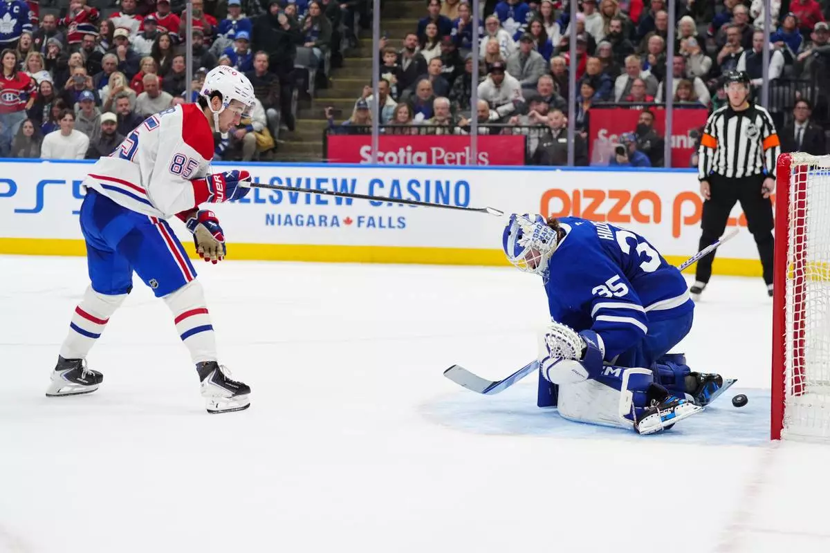 Montréal Canadiens left wing Alexandre Texier (85) scores the winning goal against Toronto Maple Leafs goaltender Dennis Hildeby (35) during shootout NHL hockey game action in Toronto, Saturday, Dec. 6, 2025. (Frank Gunn/The Canadian Press via AP)