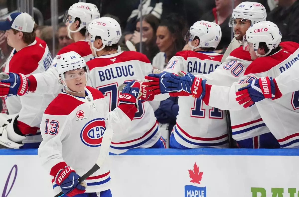 Montréal Canadiens right wing Cole Caufield (13) celebrates after his goal against the Toronto Maple Leafs with teammates on the bench during second-period NHL hockey game action in Toronto, Saturday, Dec. 6, 2025. (Frank Gunn/The Canadian Press via AP