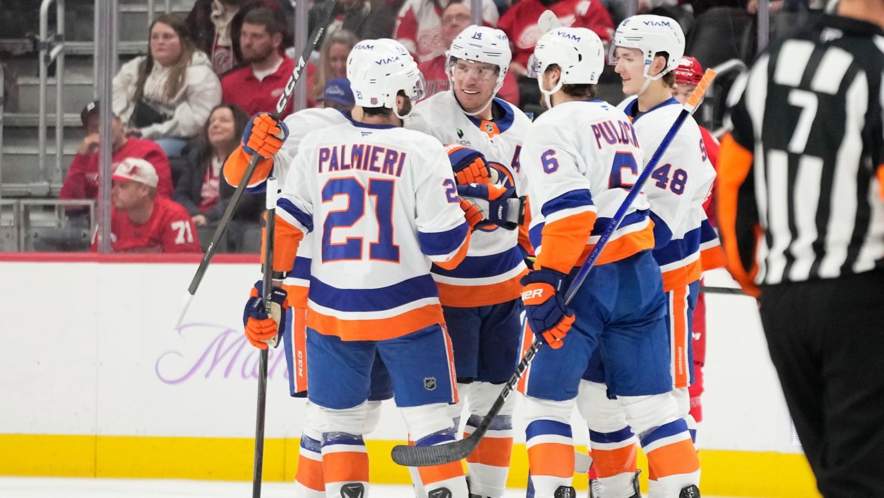 New York Islanders center Bo Horvat (14) celebrates with, from left to right, center Kyle Palmieri, defenseman Ryan Pulock, and defenseman Matthew Schaefer after scoring during the second period of an NHL hockey game against the Detroit Red Wings, Thursday, Nov. 20, 2025, in Detroit. (AP Photo/Ryan Sun)