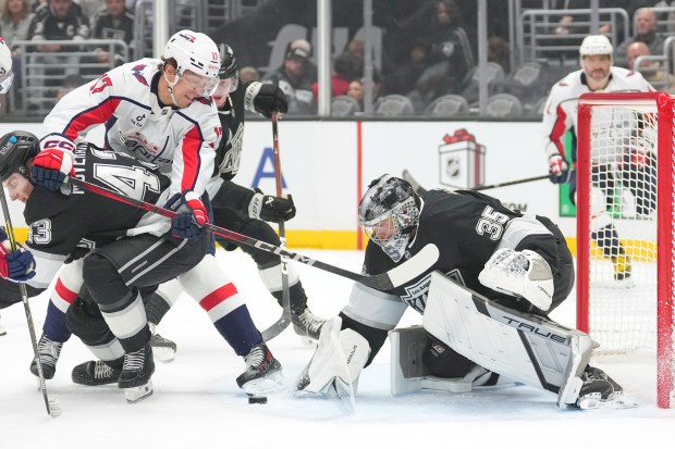 Washington Capitals center Dylan Strome, upper left, tries to score...