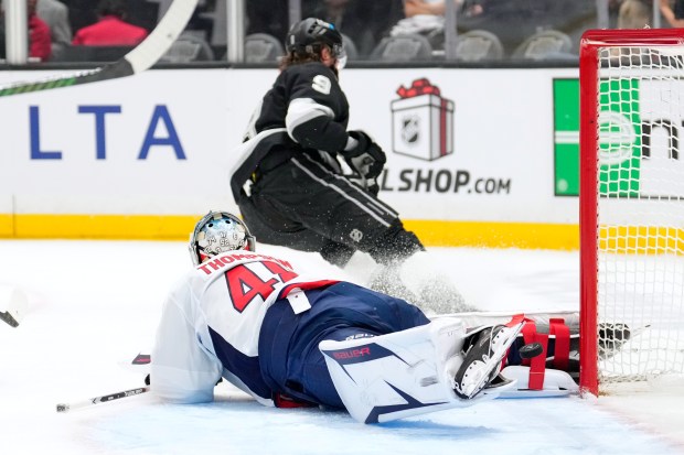 Kings right wing Adrian Kempe, top, scores past Washington Capitals...