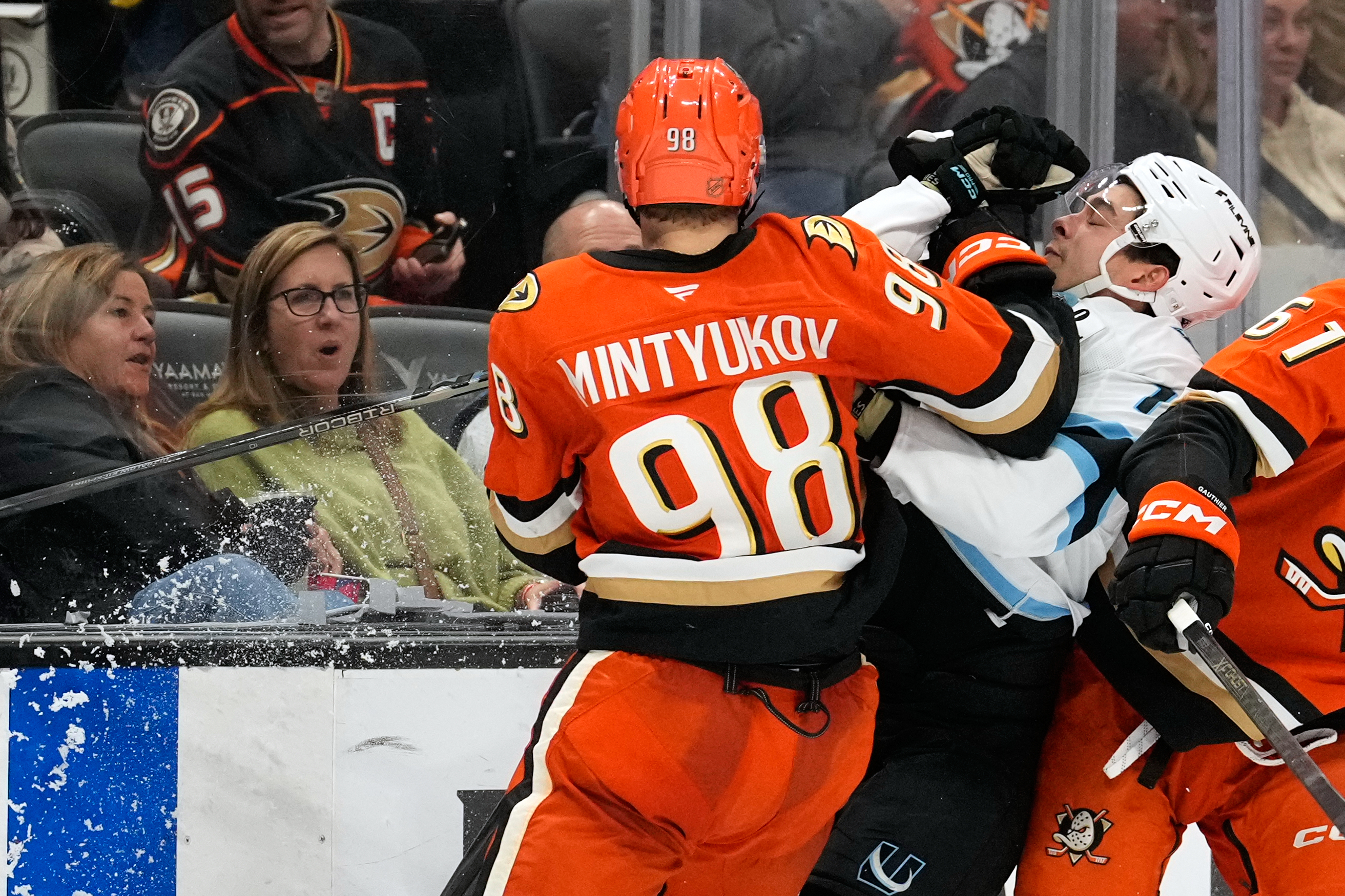 Ducks defenseman Pavel Mintyukov, left puts a hit on Utah...