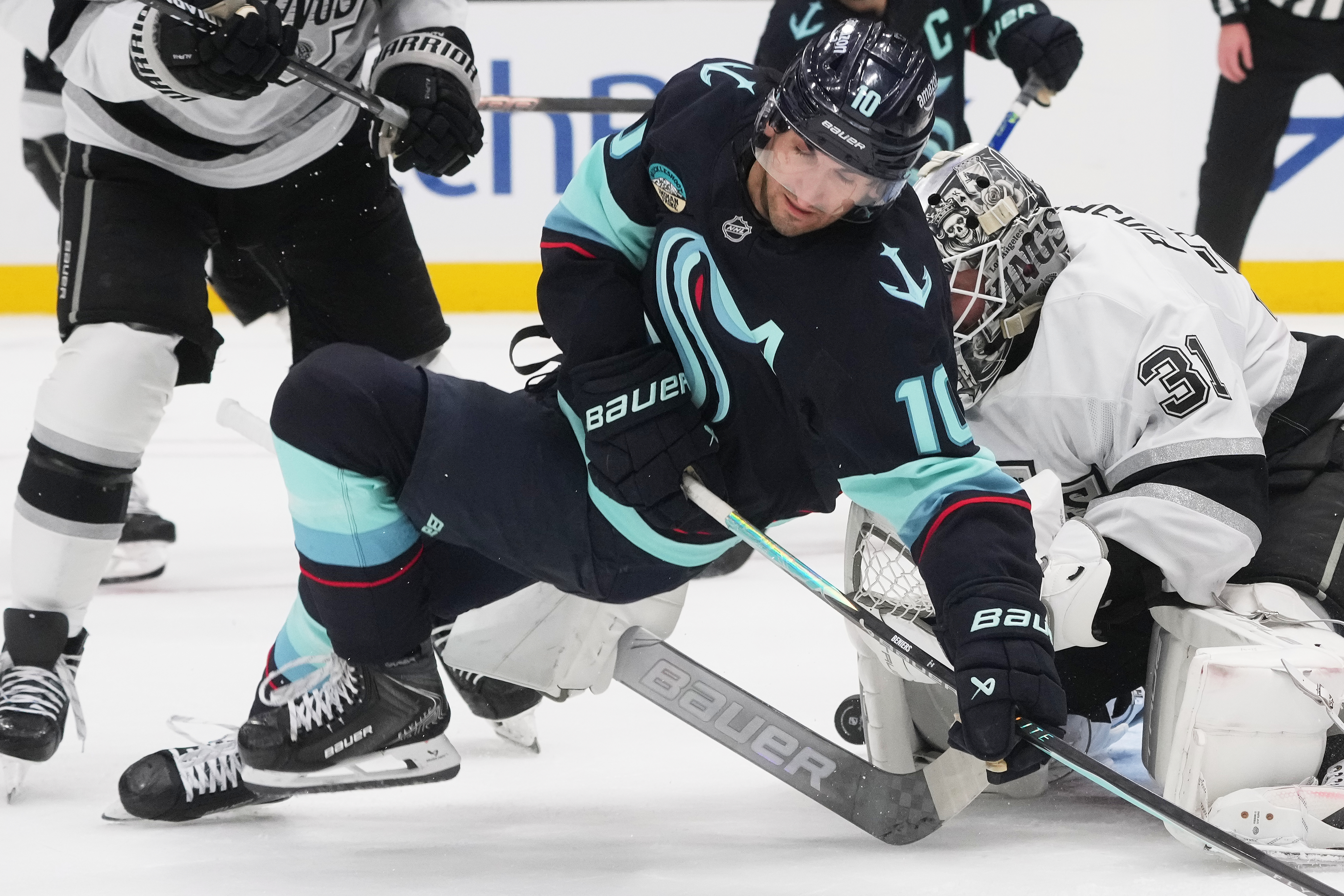 Seattle Kraken center Matty Beniers (10) falls while trying for...