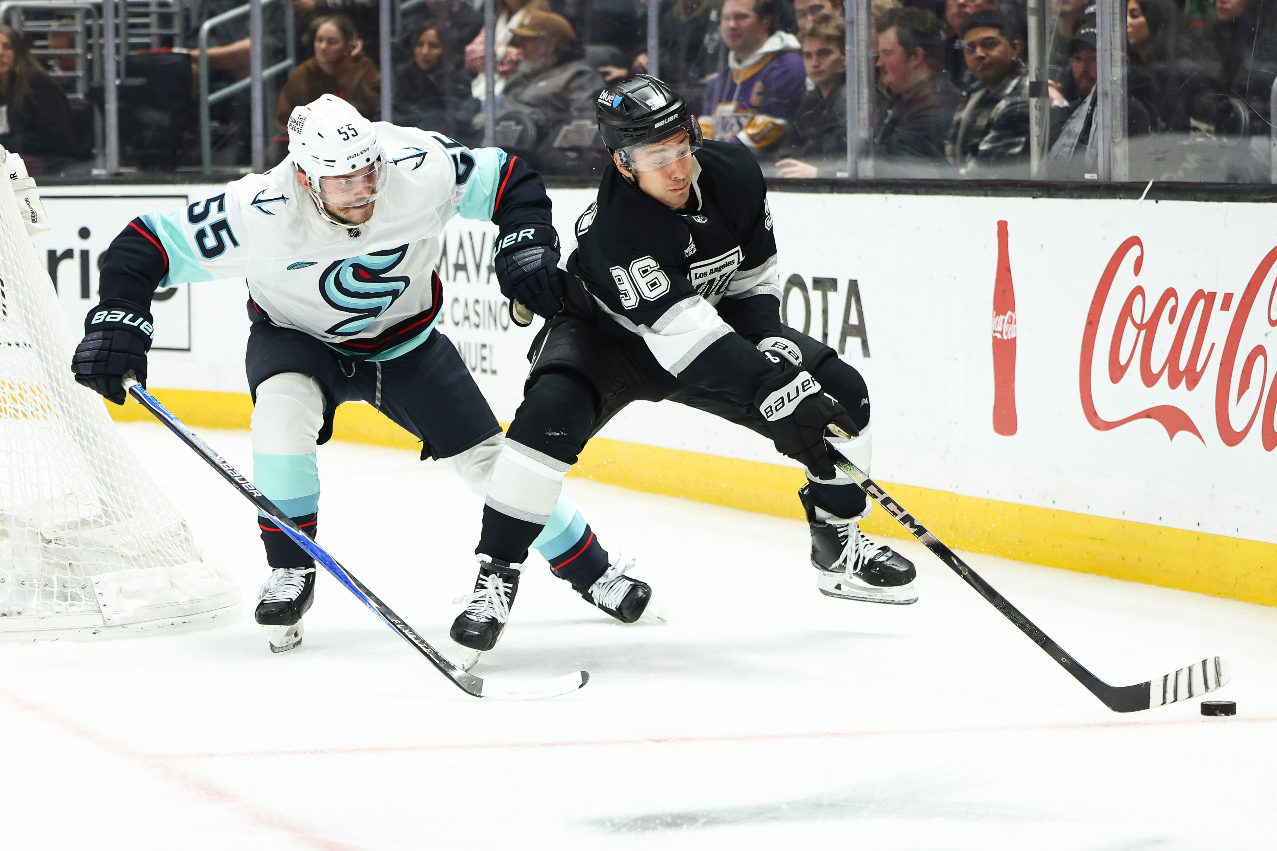 Kings left wing Andrei Kuzmenko, right, battles for the puck...