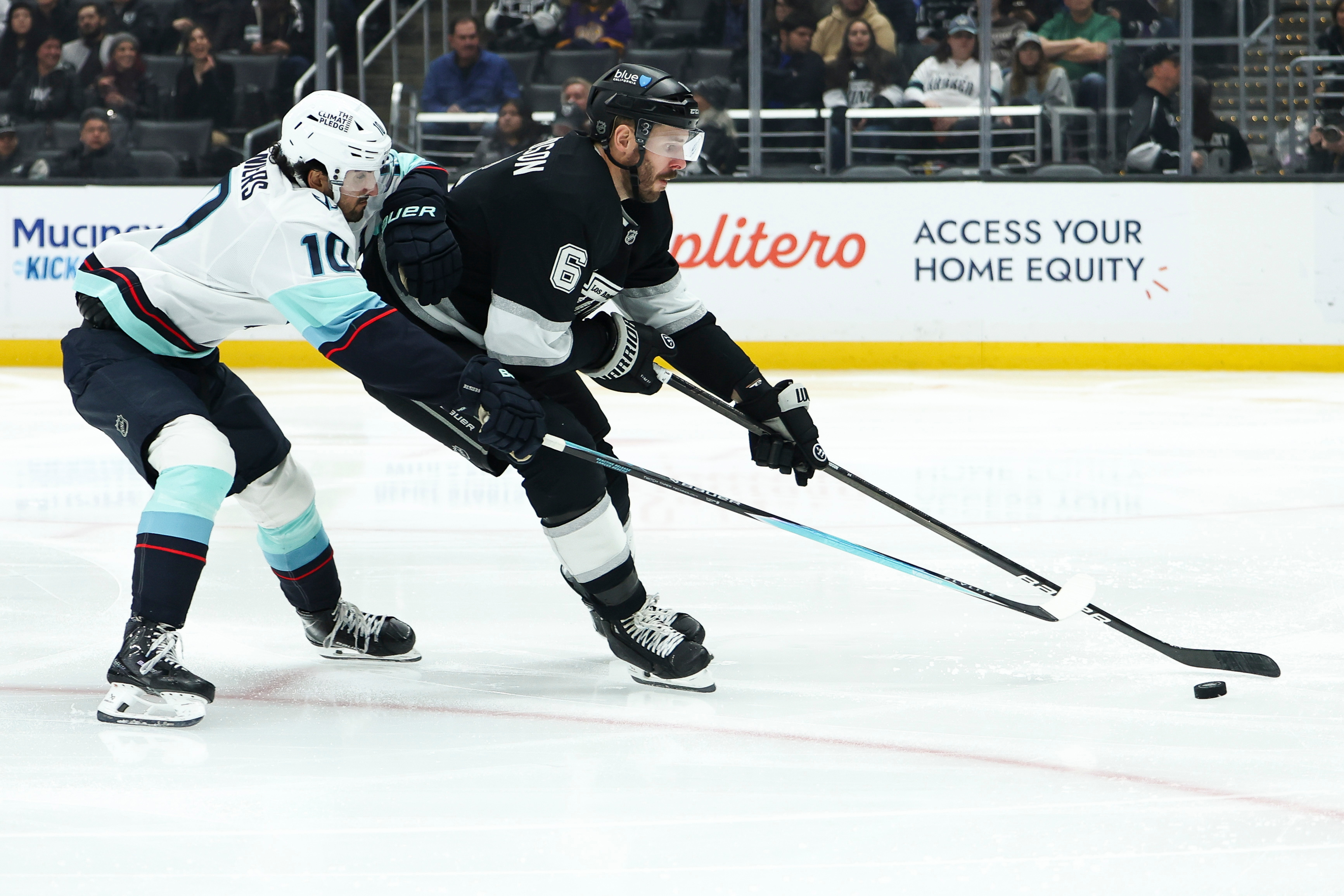Seattle Kraken center Matty Beniers, left, and Kings defenseman Joel...