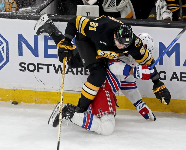 Boston Bruins defenseman Nikita Zadorov (91) goes over New York Rangers left wing Will Cuylle during New York's 6-2 victory Saturday at the TD Garden. (Staff Photo By Stuart Cahill/Boston Herald)
