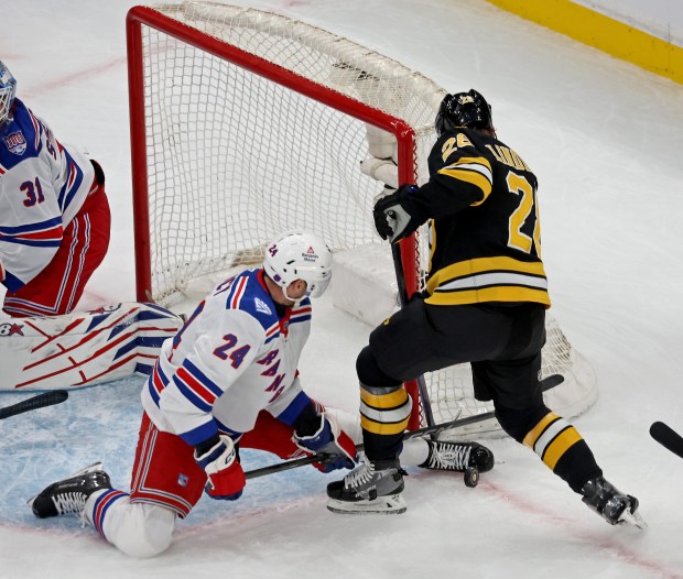 Boston Bruins center Elias Lindholm (28) digs for the rebound as New York Rangers defenseman Carson Soucy blocks the shot. (Staff Photo By Stuart Cahill/Boston Herald)