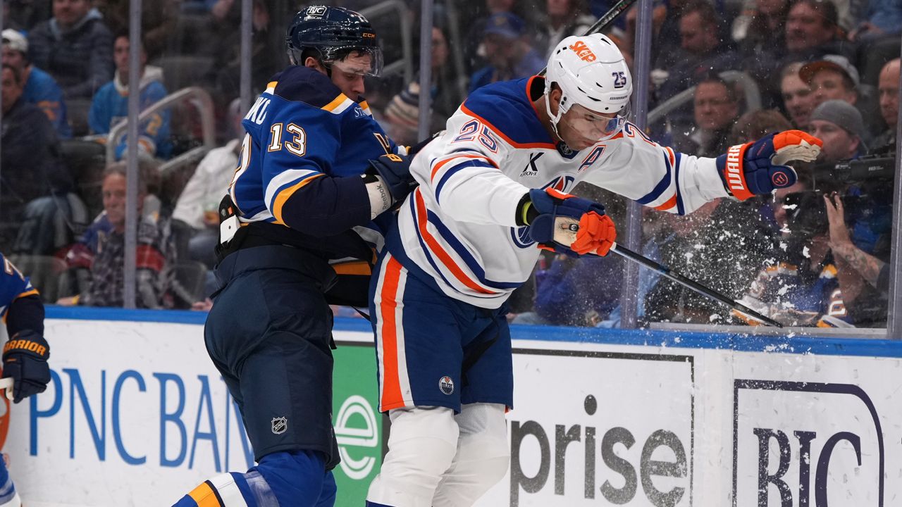 St. Louis Blues' Alexey Toropchenko (13) and Edmonton Oilers' Darnell Nurse (25) collide along the boards during the second period of an NHL hockey game Monday, Nov. 3, 2025, in St. Louis. (AP Photo/Jeff Roberson)