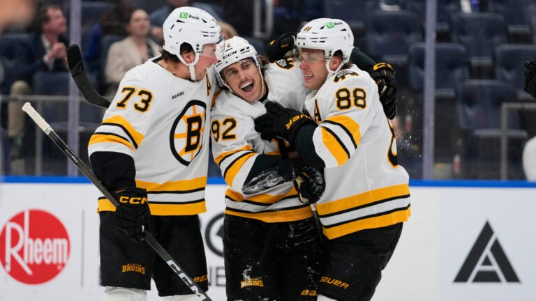 Boston Bruins' Marat Khusnutdinov (92) celebrates with David Pastrnak (88) and Charlie McAvoy (73) after scoring a goal during the third period of an NHL hockey game against the New York Islanders Tuesday, Nov. 4, 2025, at UBS Arena in Elmont, N.Y.