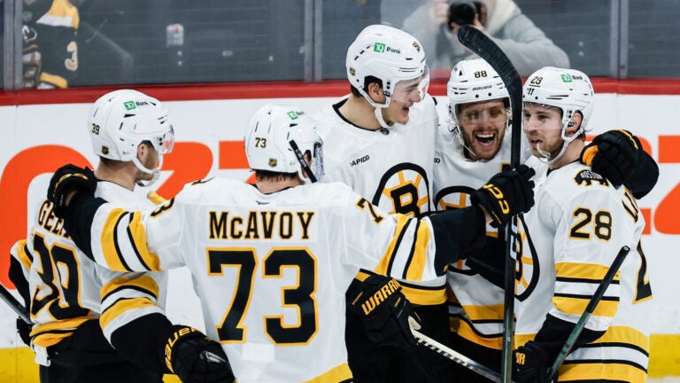 Boston Bruins players celebrate Elias Lindholm's (28) goal against the Winnipeg Jets during the third period of of an NHL hockey game, in Winnipeg, Manitoba, Thursday, Dec. 11, 2025.