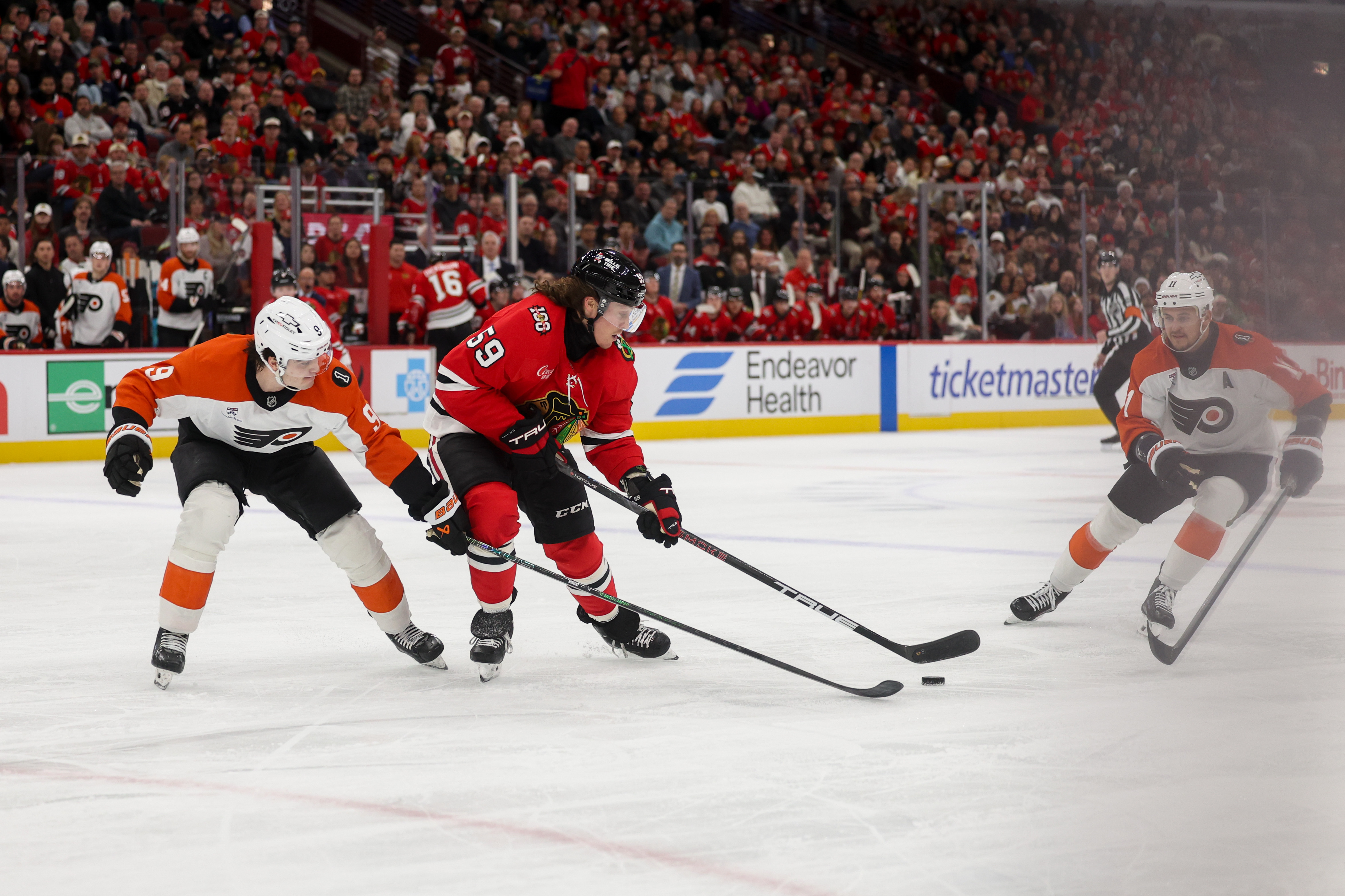 Philadelphia Flyers defenseman Jamie Drysdale (9) guards Chicago Blackhawks left wing Tyler Bertuzzi (59) while he handles the puck during the first period at the United Center Tuesday Dec. 23, 2025 in Chicago. (Armando L. Sanchez/Chicago Tribune)