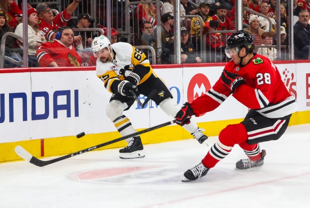 Pittsburgh Penguins defenseman Erik Karlsson (65) passes the puck past Blackhawks left wing Andre Burakovsky (28) during the first period, Dec. 28, 2025, at the United Center. (Dominic Di Palermo/Chicago Tribune)