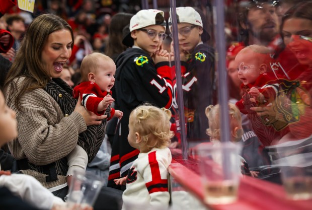 Alandra Dickinson, the wife of Blackhawks center Jason Dickinson, cheers with their daughters Delilah and Willow during warmups before game between the Blackhawks and the Pittsburgh Penguins, Dec. 28, 2025, at the United Center. (Dominic Di Palermo/Chicago Tribune)