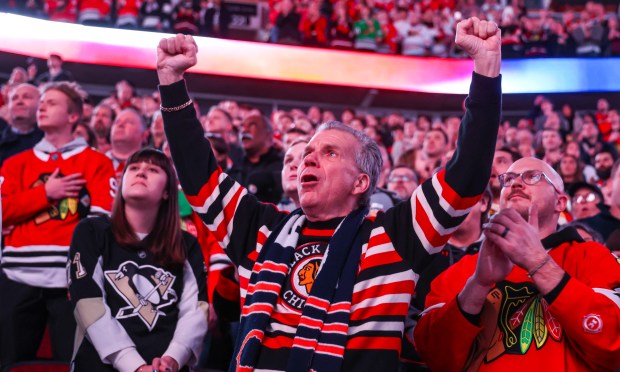 A fan cheers during the national anthem before a game between the Blackhawks and the Pittsburgh Penguins, Dec. 28, 2025, at the United Center. (Dominic Di Palermo/Chicago Tribune)