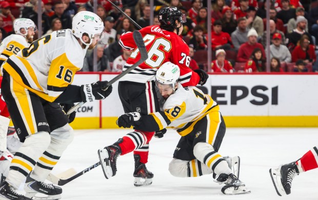 Blackhawks left wing Nick Lardis (76) and Pittsburgh Penguins center Tommy Novak (18) collide during the second period, Dec. 28, 2025, at the United Center. (Dominic Di Palermo/Chicago Tribune)