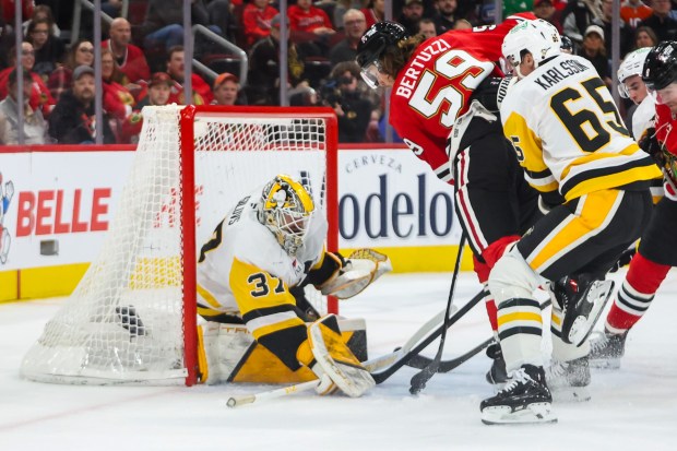 Blackhawks left wing Tyler Bertuzzi (59) gets checked by Pittsburgh Penguins defenseman Erik Karlsson (65) while shooting on goal during the first period, Dec. 28, 2025, at the United Center. (Dominic Di Palermo/Chicago Tribune)