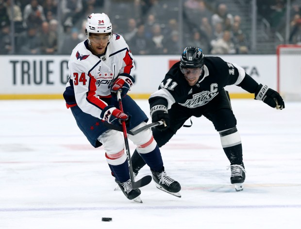 The Washington Capitals’ Justin Sourdif, left, skates away from Kings...