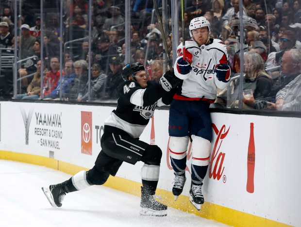 Kings defenseman Mikey Anderson, left, collides with Washington Capitals left...