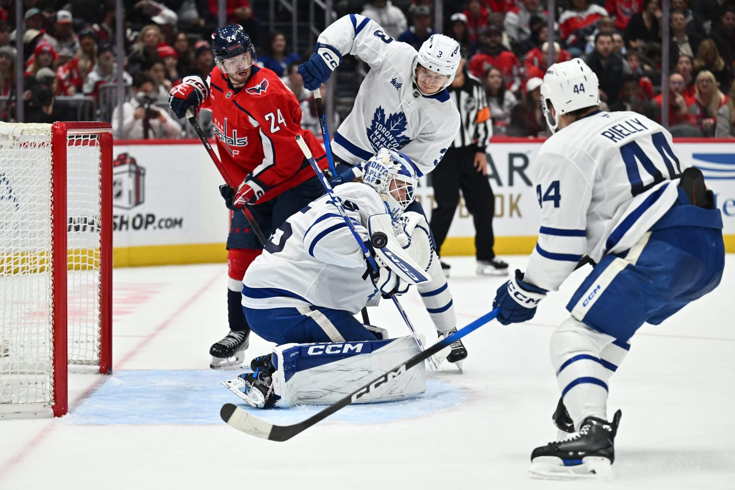 Leafs goalie Dennis Hildeby blocks a shot with two other Leafs and a Capitals player looking on.