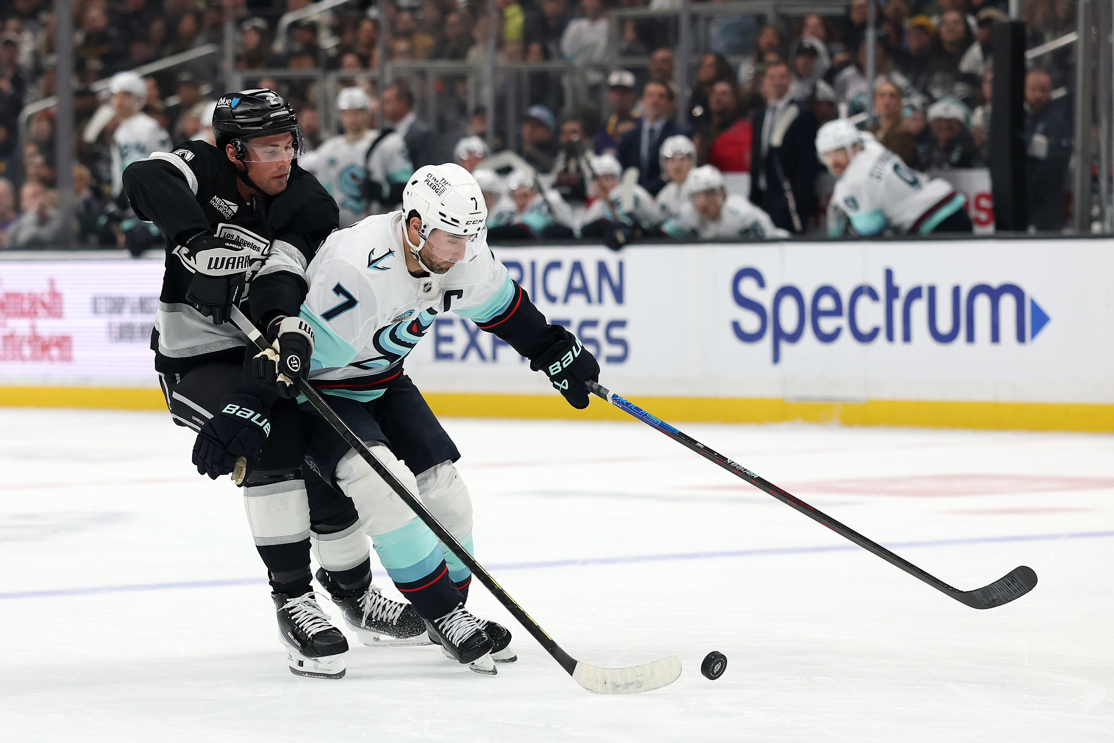 The Seattle Kraken’s Jordan Eberle, right, skates with the puck...