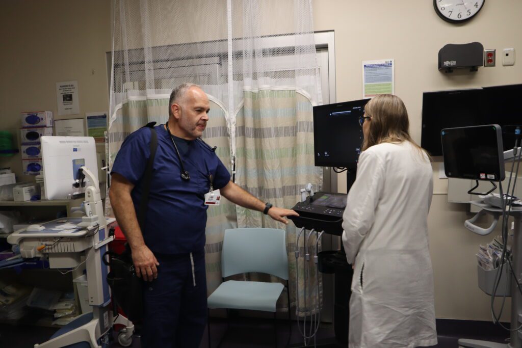 A man in scrubs speaks to a woman in a doctor's coat at a hospital in East San Jose, California