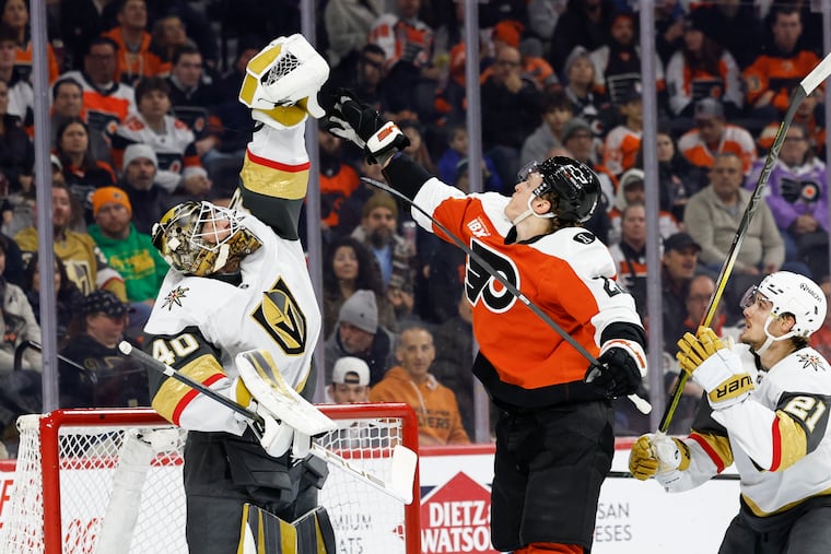 Vegas Golden Knights goaltender Akira Schmidt and Flyers center Christian Dvorak battle for the puck during Thursday night's game.