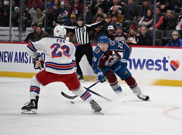 New York Rangers defenseman Adam Fox (23), left, and Colorado Avalanche center Nathan MacKinnon (29) battle for the puck during the first period as the Colorado Avalanche take on the New York Rangers at Ball Aren in Denver, Colorado on Nov. 20, 2025. (Photo by RJ Sangosti/The Denver Post)
