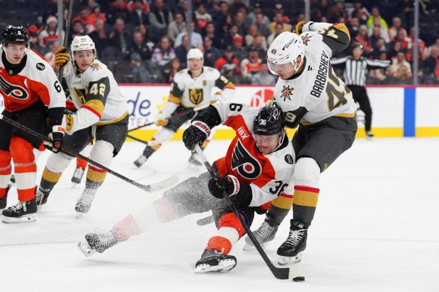 Philadelphia Flyers' Emil Andrae, center, is tripped by Vegas Golden Knights' Ivan Barbashev (49) during the first period of an NHL hockey game, Thursday, Dec. 11, 2025, in Philadelphia. (AP Photo/Derik Hamilton)