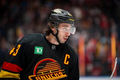 Vancouver Canucks defenseman Quinn Hughes reacts during 2025 game.