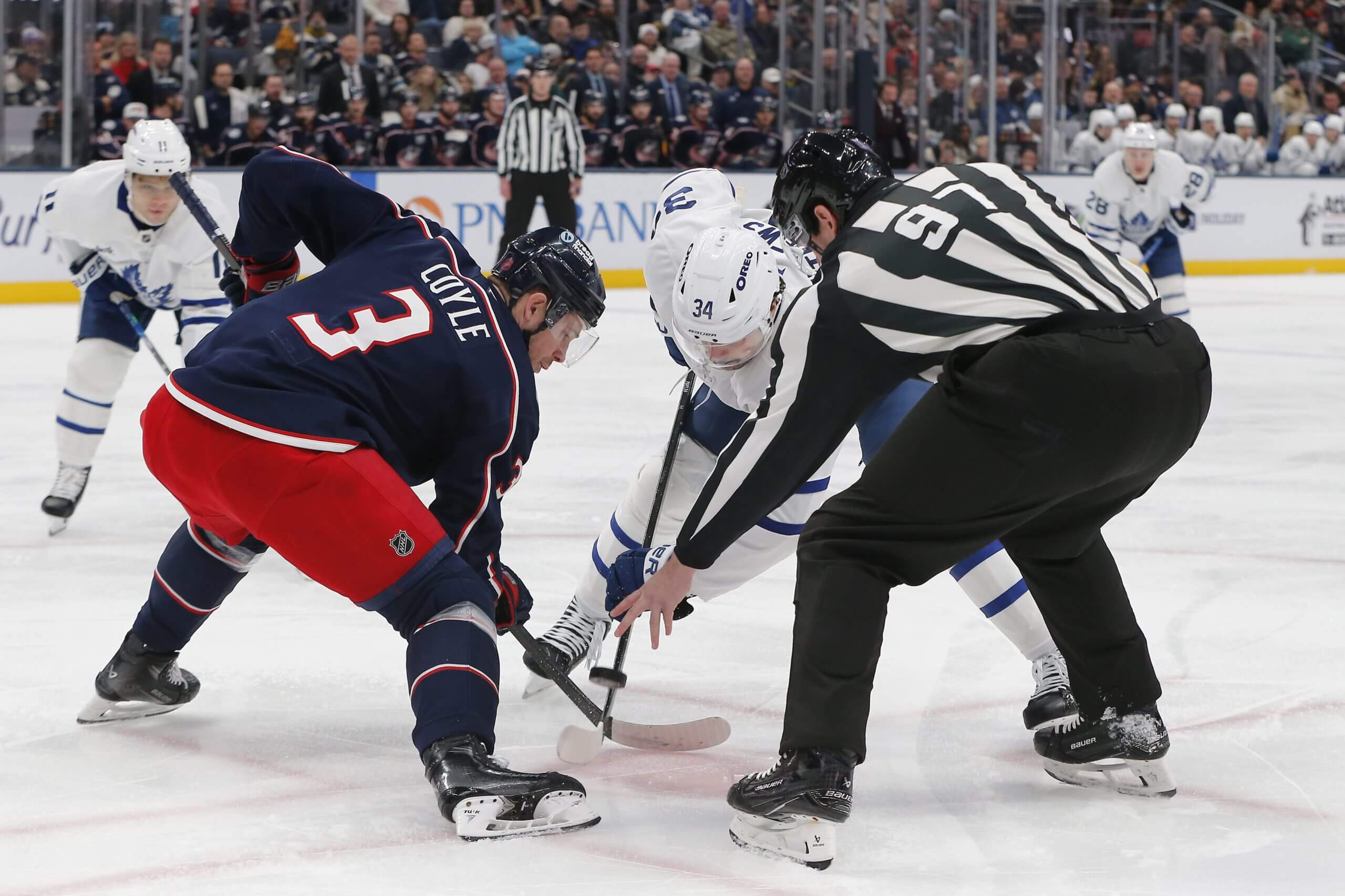 Charlie Coyle takes a faceoff against the Toronto Maple Leafs.