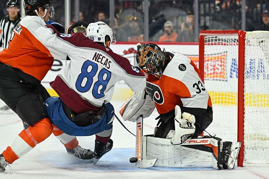 Dec 7, 2025; Philadelphia, Pennsylvania, USA; Philadelphia Flyers goaltender Samuel Ersson (33) makes a save as Colorado Avalanche center Martin Necas (88) and Philadelphia Flyers defenseman Travis Sanheim (6) collide during the second period at Xfinity Mobile Arena.