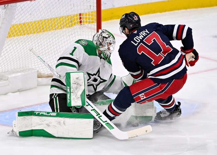 Dallas Stars' goaltender Casey DeSmith (1) makes a save on Winnipeg Jets' Adam Lowry (17)...