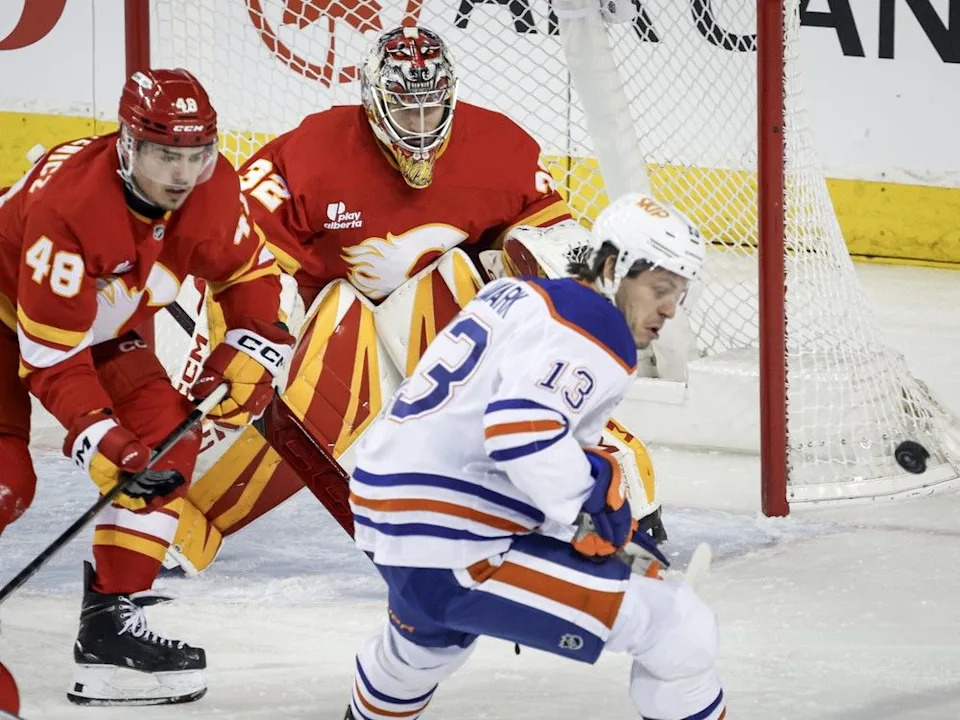  Flames goalie Dustin Wolf and defenceman Hunter Brzustewicz keep tabs on Oilers forward Mattias Janmark.