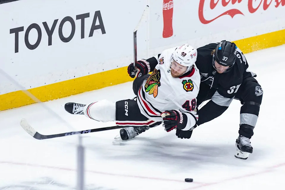 Los Angeles Kings left wing Warren Foegele (31) records a penalty by tripping Chicago Blackhawks defense Matt Grzelcyk (48) during an NHL game against the Chicago Blackhawks on December 6, 2025 in Los Angeles, Calif.