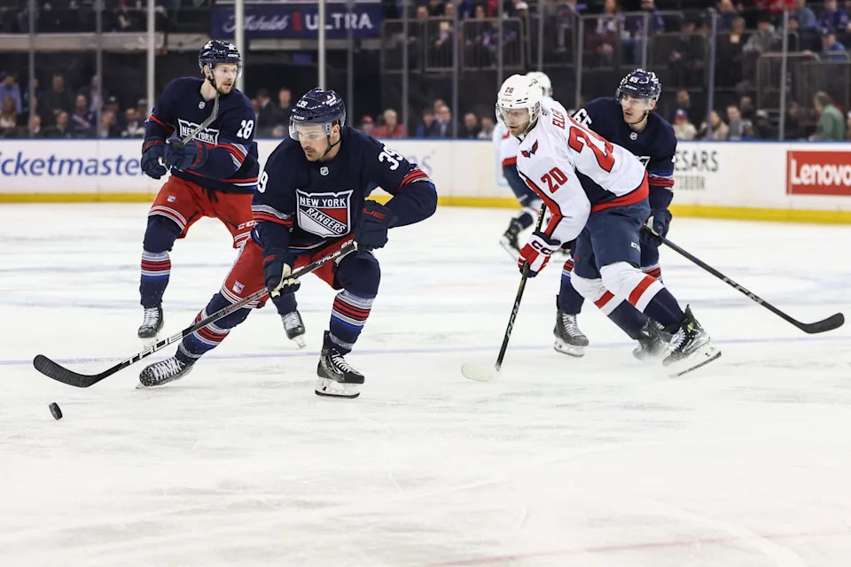 Mar 5, 2025; New York, New York, USA; New York Rangers center Sam Carrick (39) and Washington Capitals center Lars Eller (20) chase the puck in the first period at Madison Square Garden.