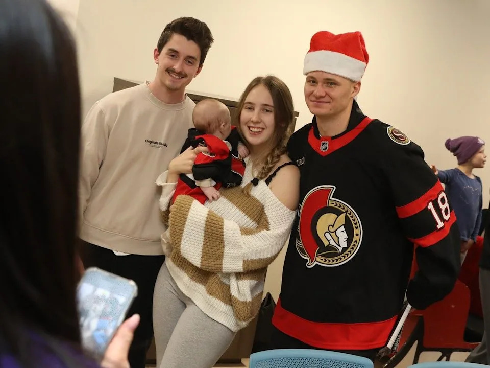  Tim Stützle of the Ottawa Senators is photographed with Cedric Bérubé (L), Anna Mallabone and their baby of 2.5 months Ollie Matteo Mallabone-Bérubé.