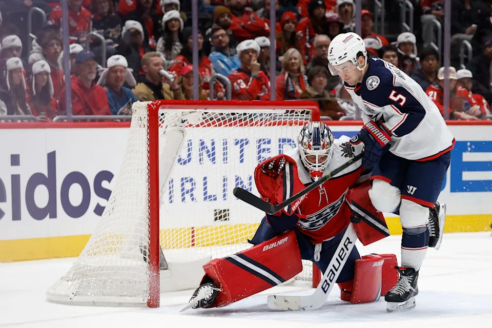 Dec 7, 2025; Washington, District of Columbia, USA; Washington Capitals goaltender Logan Thompson (48) makes a save while being run into by Columbus Blue Jackets defenseman Denton Mateychuk (5) during the second period at Capital One Arena. Mandatory Credit: Geoff Burke-Imagn Images
