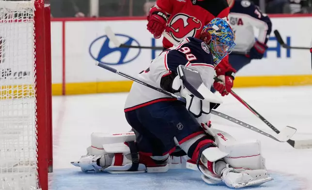Columbus Blue Jackets goaltender Elvis Merzlikins defends the goal during the second period of an NHL hockey game against the New Jersey Devils in Newark, N.J., Monday, Dec. 1, 2025. (AP Photo/Seth Wenig)