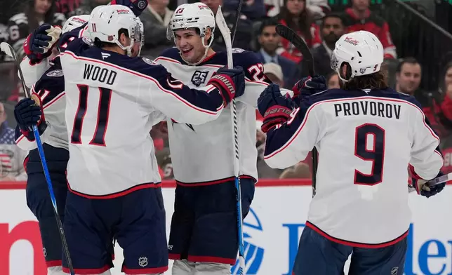 Columbus Blue Jackets' Sean Monahan, center, celebrates his goal with teammates during the third period of an NHL hockey game against the New Jersey Devils in Newark, N.J., Monday, Dec. 1, 2025. (AP Photo/Seth Wenig)