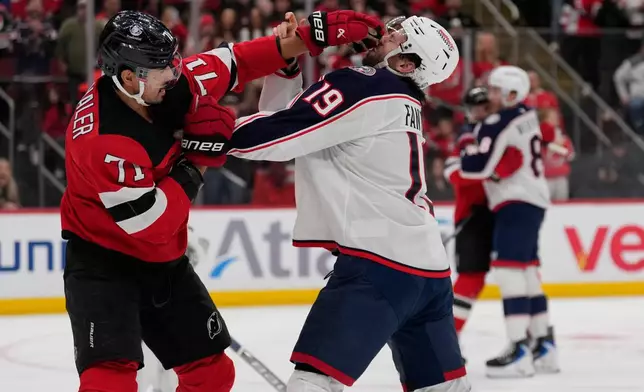 New Jersey Devils' Jonas Siegenthaler, left, and Columbus Blue Jackets' Adam Fantilli fight during the second period of an NHL hockey game in Newark, N.J., Monday, Dec. 1, 2025. (AP Photo/Seth Wenig)