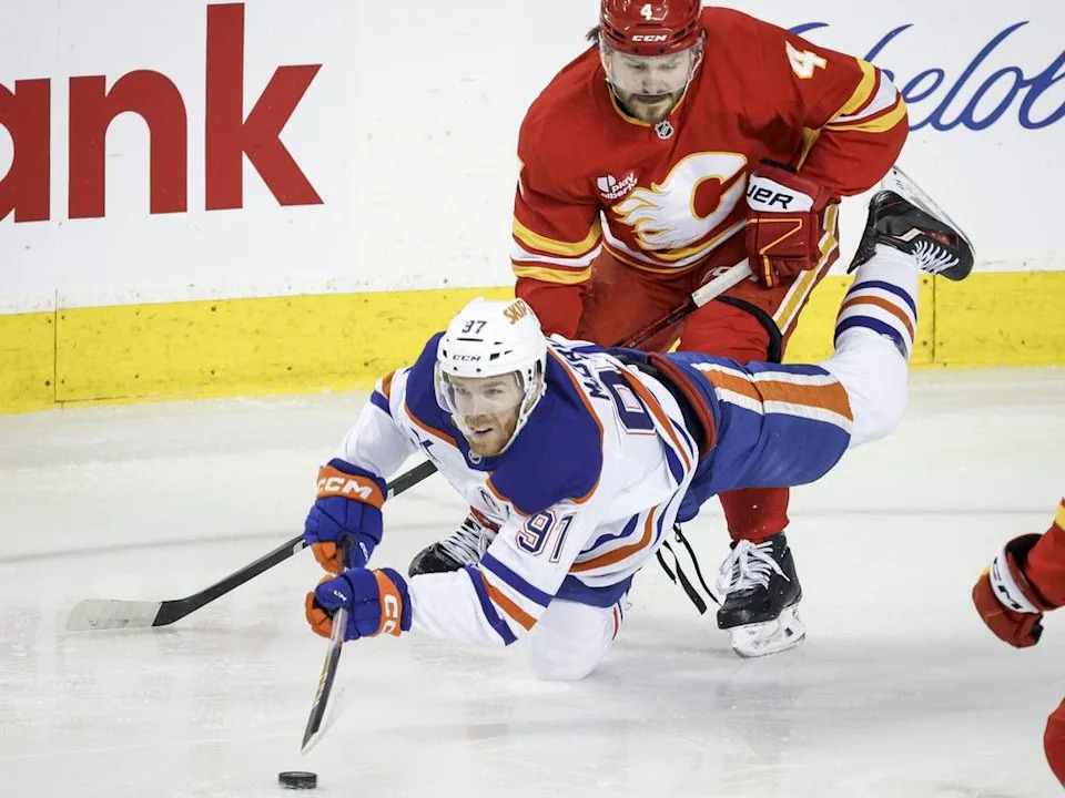  Flames defenceman Rasmus Andersson checks Oilers forward Connor McDavid during Saturday’s game.