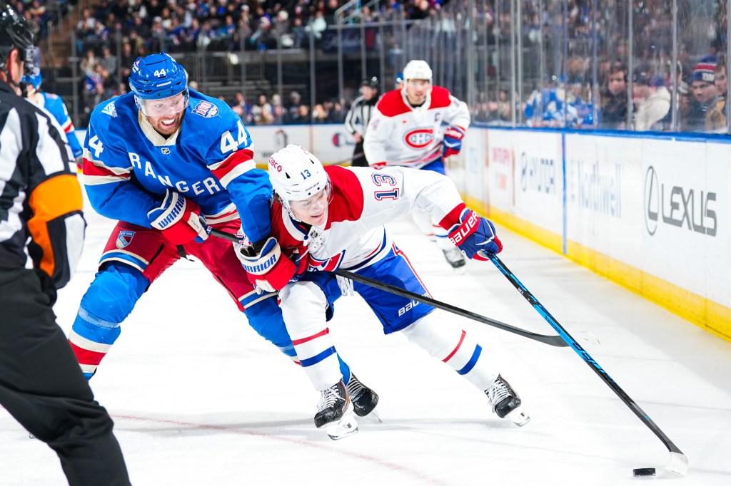 Cole Caufield of the Montreal Canadiens skates with the puck against Vladislav Gavrikov of the New York Rangers.