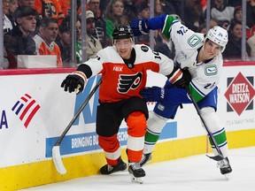 Philadelphia Flyers' Bobby Brink, left, and Vancouver Canucks' Zeev Buium battle along the boards during the second period on Monday, Dec. 22, 2025, in Philadelphia.