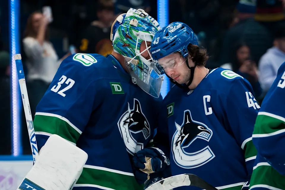 Vancouver Canucks goalie Kevin Lankinen (32) and defenseman Quinn Hughes celebrate a victory against the Columbus Blue Jackets.Bob Frid-Imagn Images