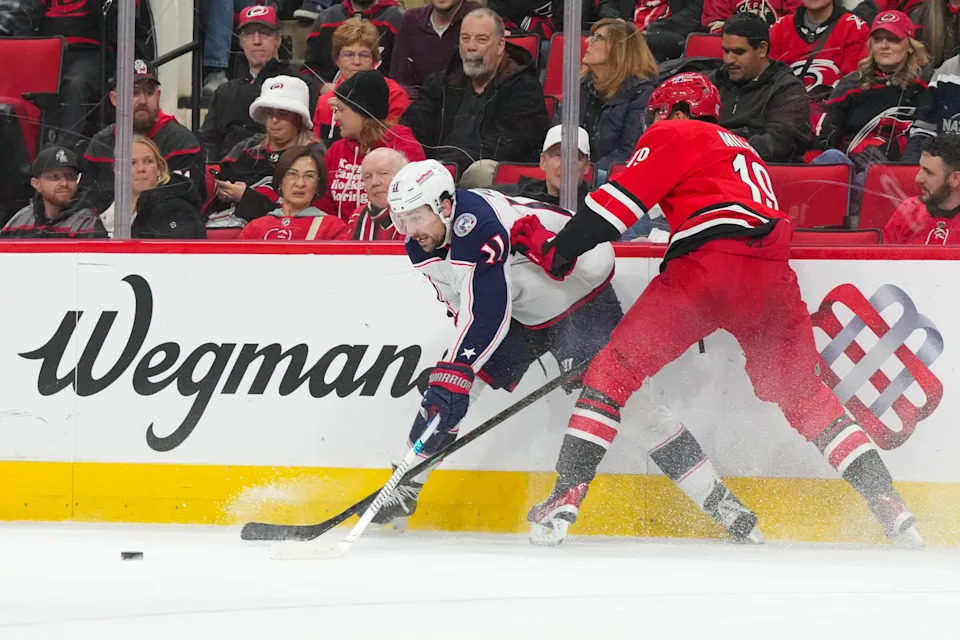 Dec 9, 2025; Raleigh, North Carolina, USA; Carolina Hurricanes defenseman K'Andre Miller (19) and Columbus Blue Jackets left wing Miles Wood (11) battle over the puck during the second period at Lenovo Center. Mandatory Credit: James Guillory-Imagn Images