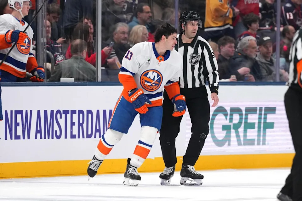 Linesman Andrew Smith #51 skates Mathew Barzal #13 of the Islanders to the penalty box after being called for slashing on Mason Marchment #17 of the Columbus Blue Jackets during the second period at Nationwide Arena on December 28, 2025 in Columbus, Ohio. Getty Images