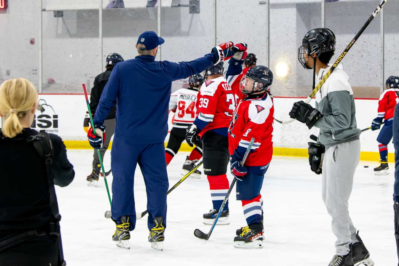 Alex Ovechkin high-fives Nate Miller at the American Special Hockey Association clinic